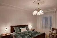 Mosazné stolní lampy se skleněnou kupolí a křišťálovými ověsy na nočních stolcích v ložnici