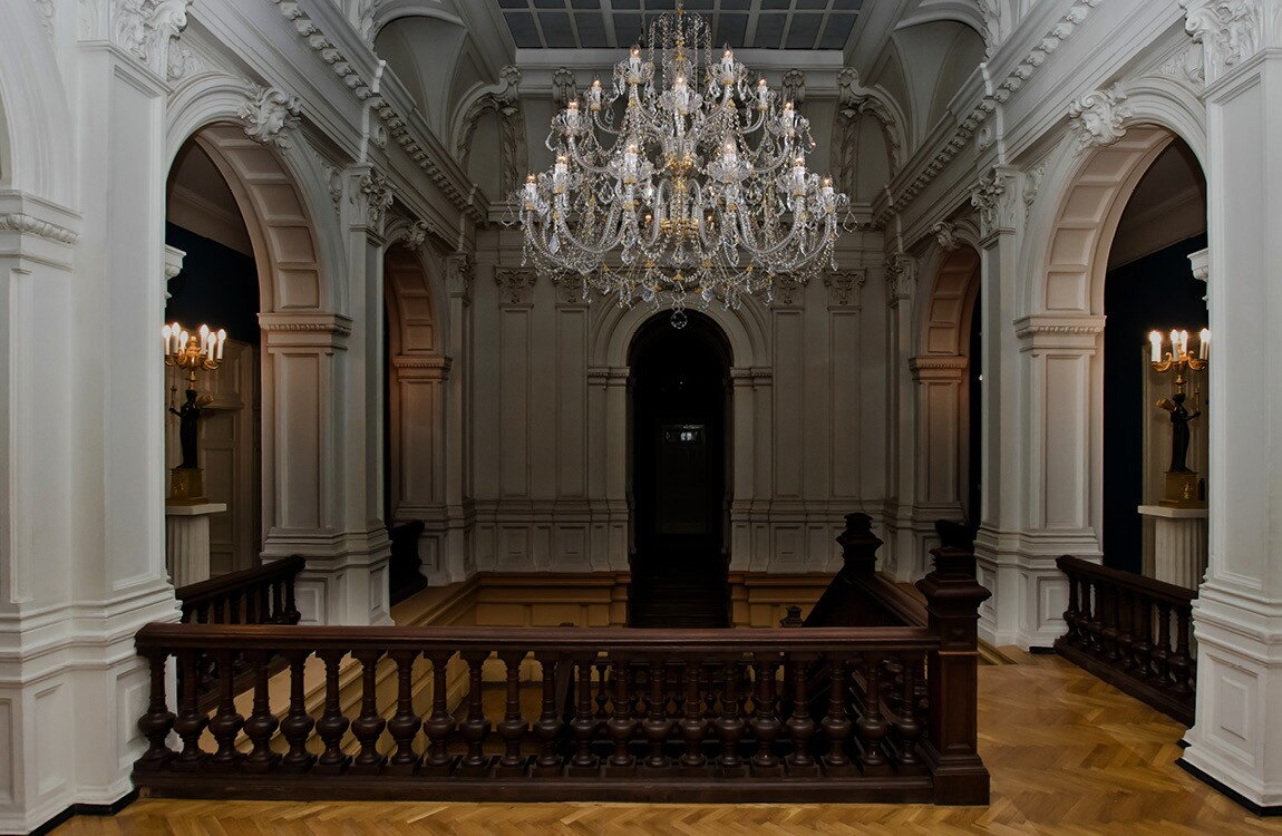 Large crystal chandelier above the staircase in chateau style LUCH24